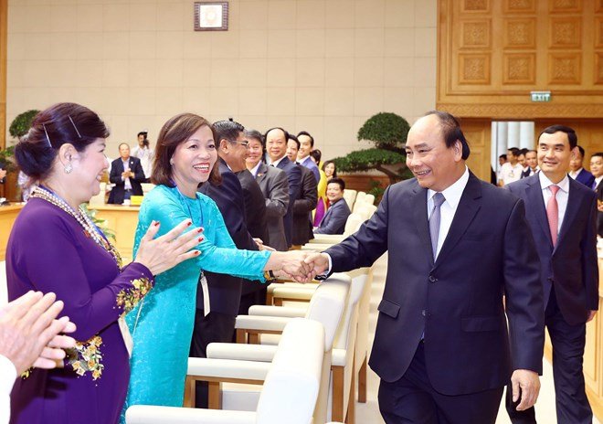 Prime Minister Nguyen Xuan Phuc (R) greets representatives from the Vietnam Private Business Association at the event in Hanoi on June 17 (Photo: VNA)